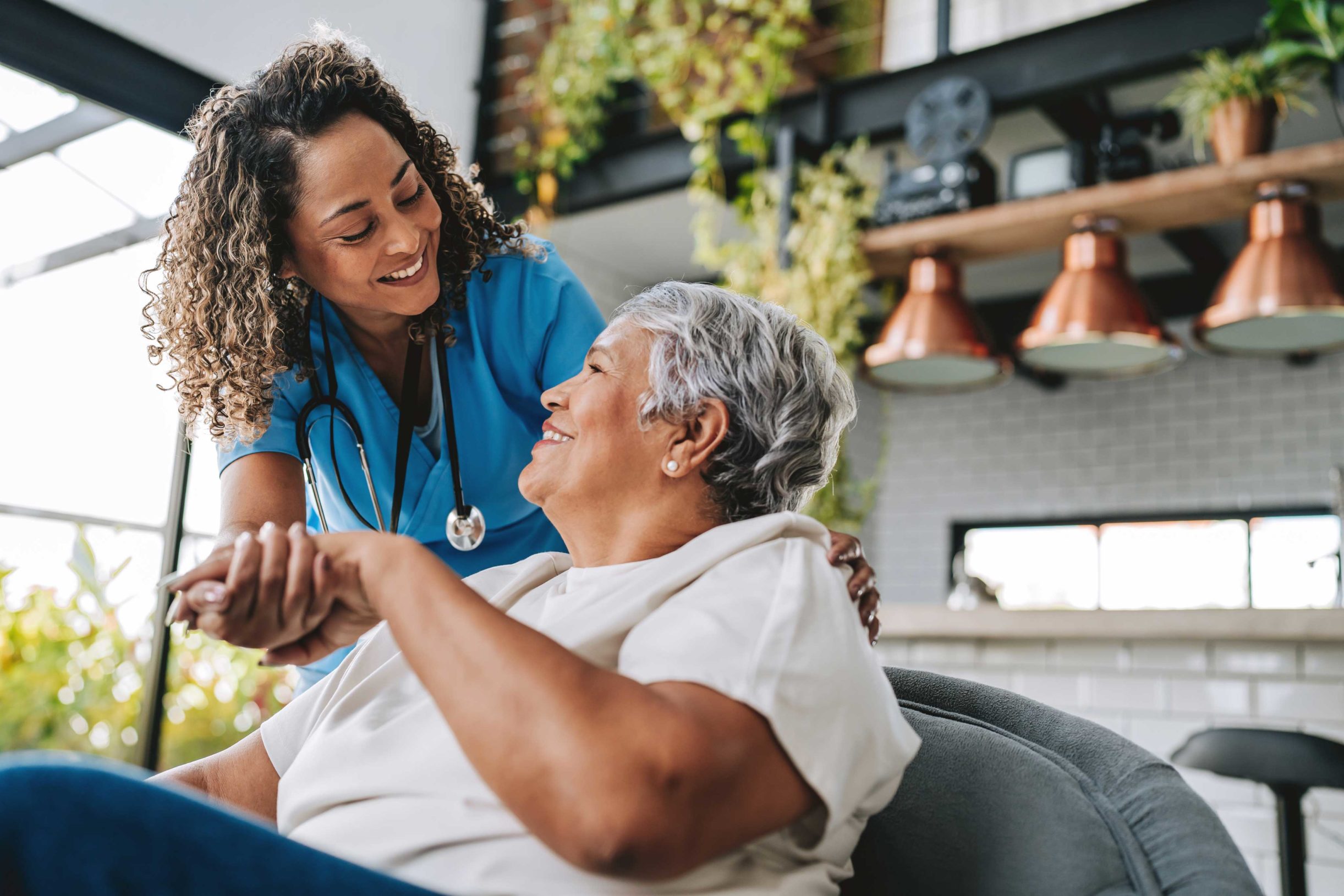 A care team member provides compassionate support to an older adult in her home.